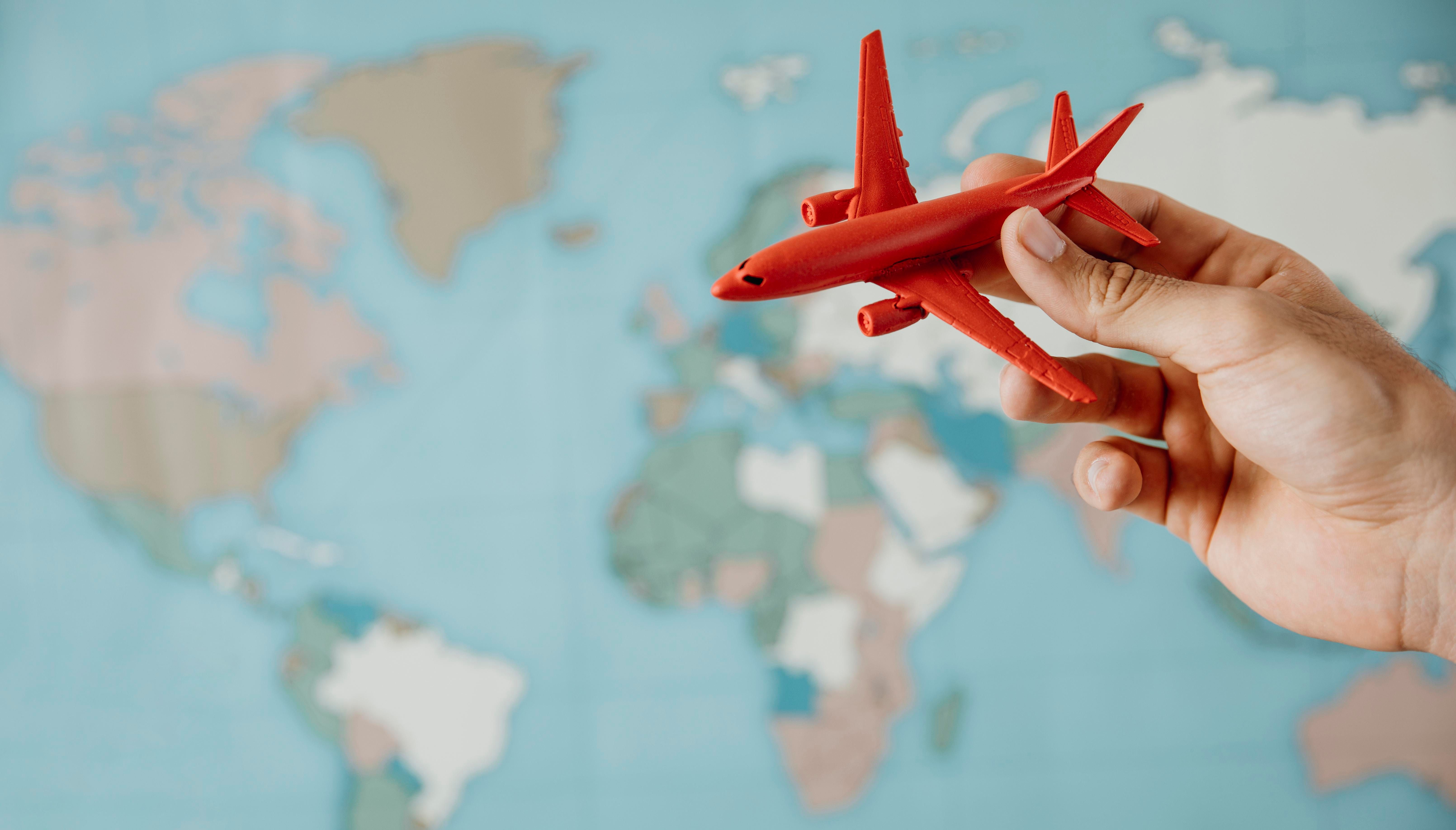 side-view-person-holding-airplane-figurine-map.jpg